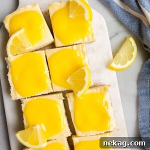 Close-up of lemon cheesecake bars, showcasing their vibrant lemon glaze and a hint of graham cracker crust.