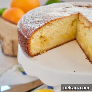 A citrus curd cake with a slice elegantly removed, showcasing the moist interior and a hint of its creamy filling.