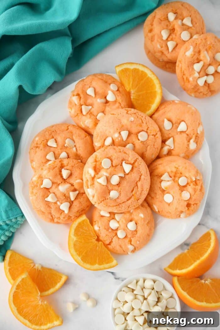 Orange Dreamsicle Delights 3 A plate featuring freshly baked orange creamsicle cookies, highlighting their vibrant color and scattered white chocolate chips.