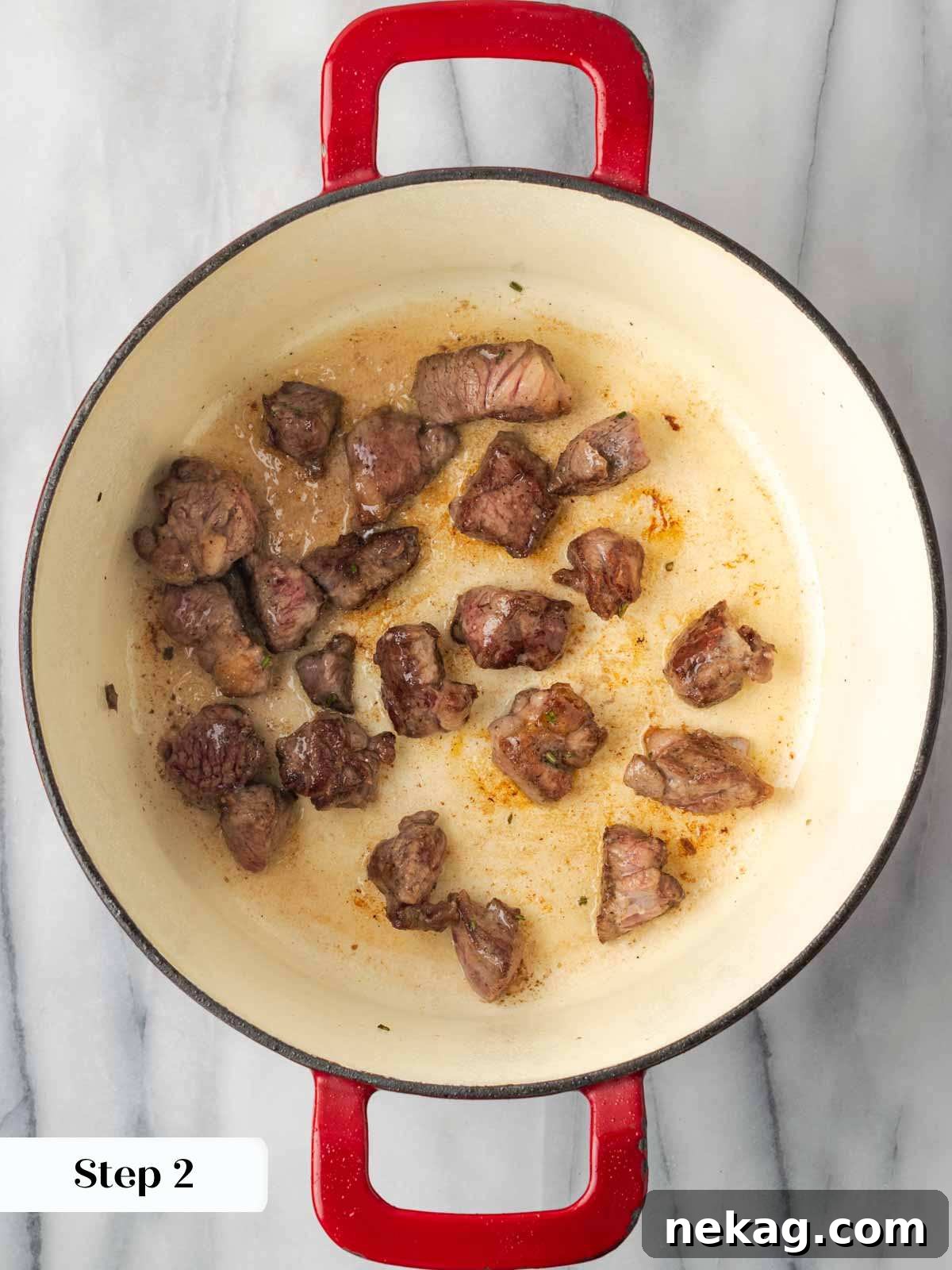 Hearty Lamb Stew 7 Lamb pieces browning perfectly in a large Dutch oven, creating a rich crust.