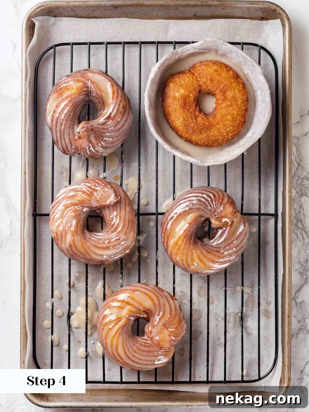 Rippled Golden Doughnuts 17 Freshly fried French crullers being dipped and glazed on a wire rack, with sweet maple glaze dripping down, signifying completion.