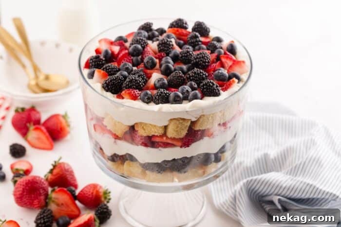 Festive Red White and Blue Trifle Video Tutorial 9 A close-up of a 4th of July trifle in a clear bowl, highlighting the defined layers of cake, whipped cream, and mixed berries.