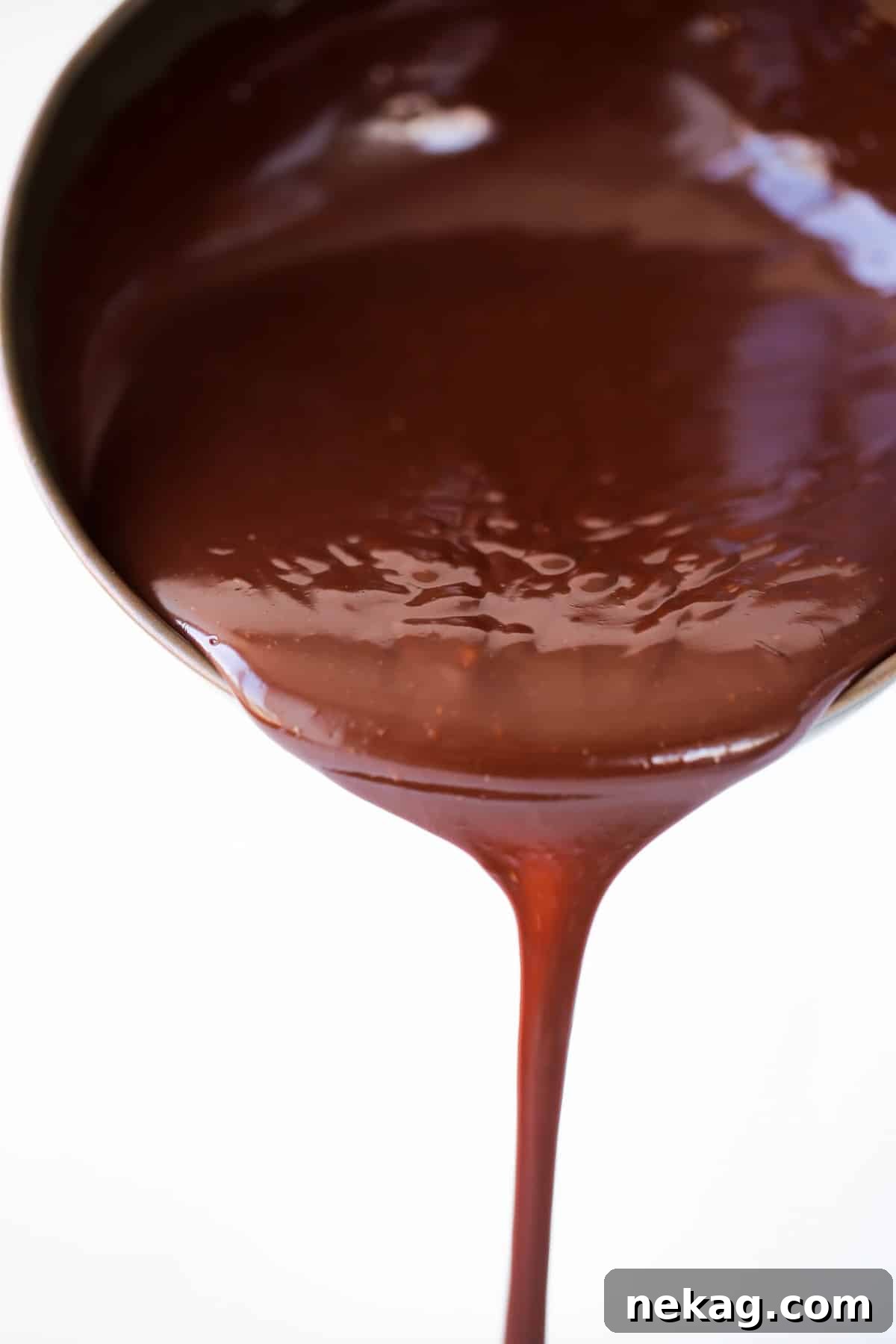 Mastering Chocolate Ganache 2 chocolate ganache pouring in one stream from pot.