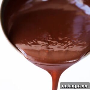 Mastering Chocolate Ganache 12 chocolate ganache pouring in one stream from copper pot.