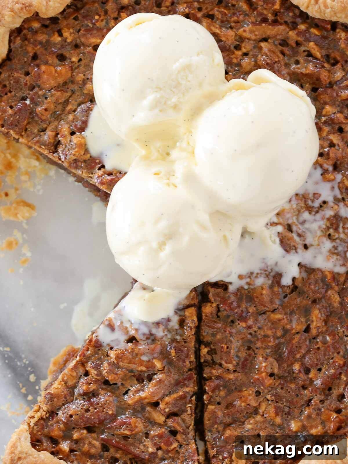 Velvet Vanilla Bean Indulgence 3 A slice of pecan pie garnished with two generous scoops of vanilla bean ice cream, highlighting its perfect pairing potential.