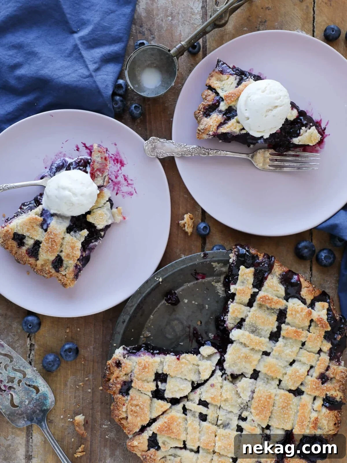 Velvet Vanilla Bean Indulgence 5 A beautifully sliced blueberry pie arranged on pink plates against a rustic wooden background.