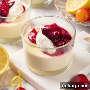 Three lemon possets in glasses with whipped cream and cherry sauce.