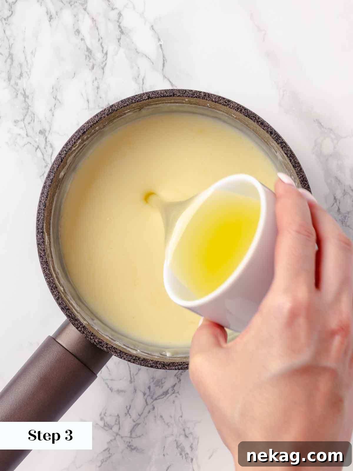 Velvet Lemon Delight 7 A hand pouring fresh lemon juice into the hot, thickened cream mixture in a saucepan, immediately after it has been removed from the heat.
