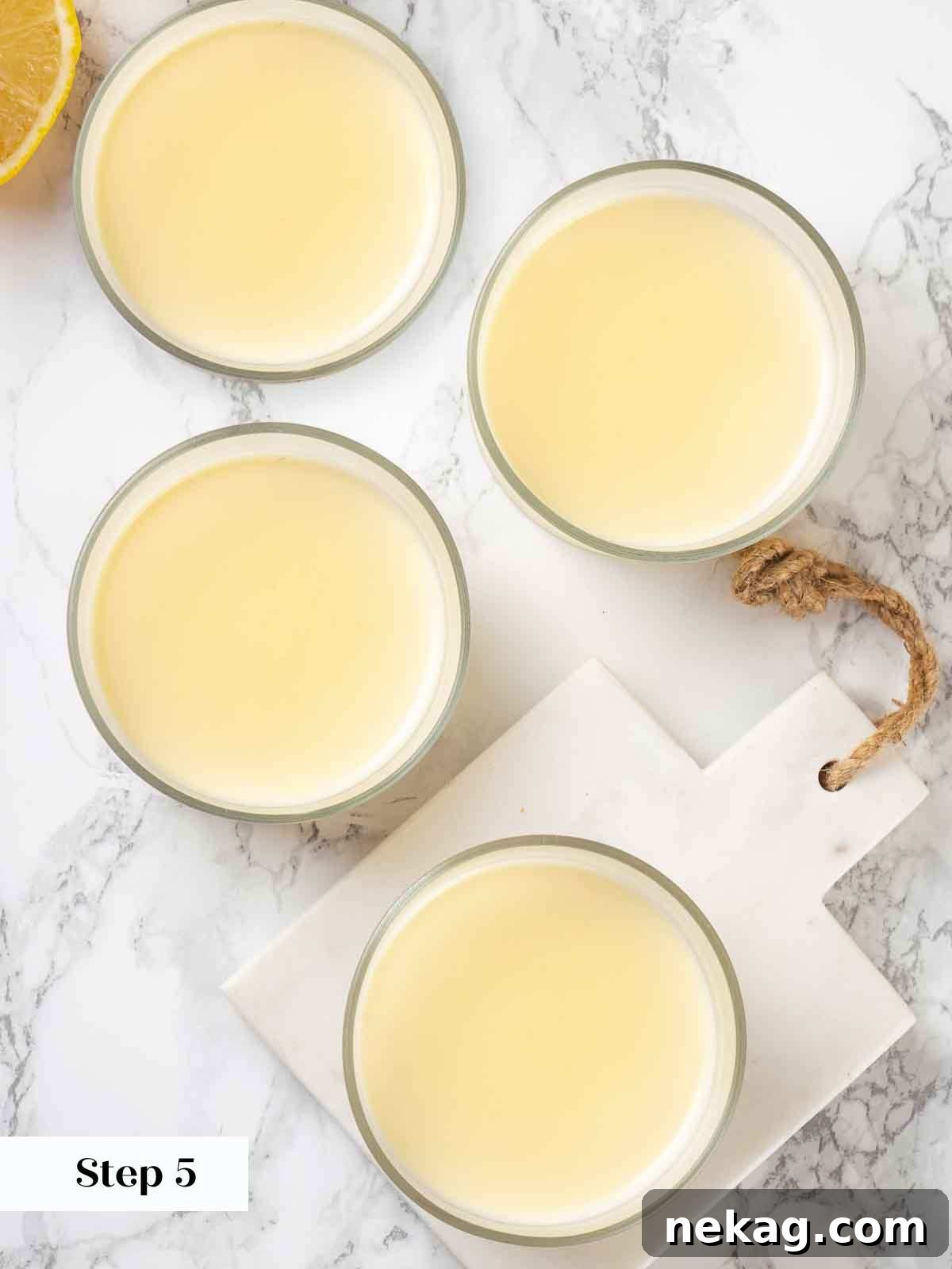Velvet Lemon Delight 9 Several individual serving glasses filled with the strained lemon posset mixture, arranged in a refrigerator for chilling to set.