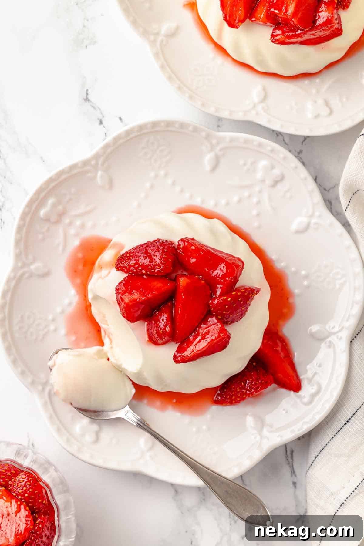 Silken Buttermilk Delight 3 Overhead shot of buttermilk panna cotta garnished with macerated strawberries.