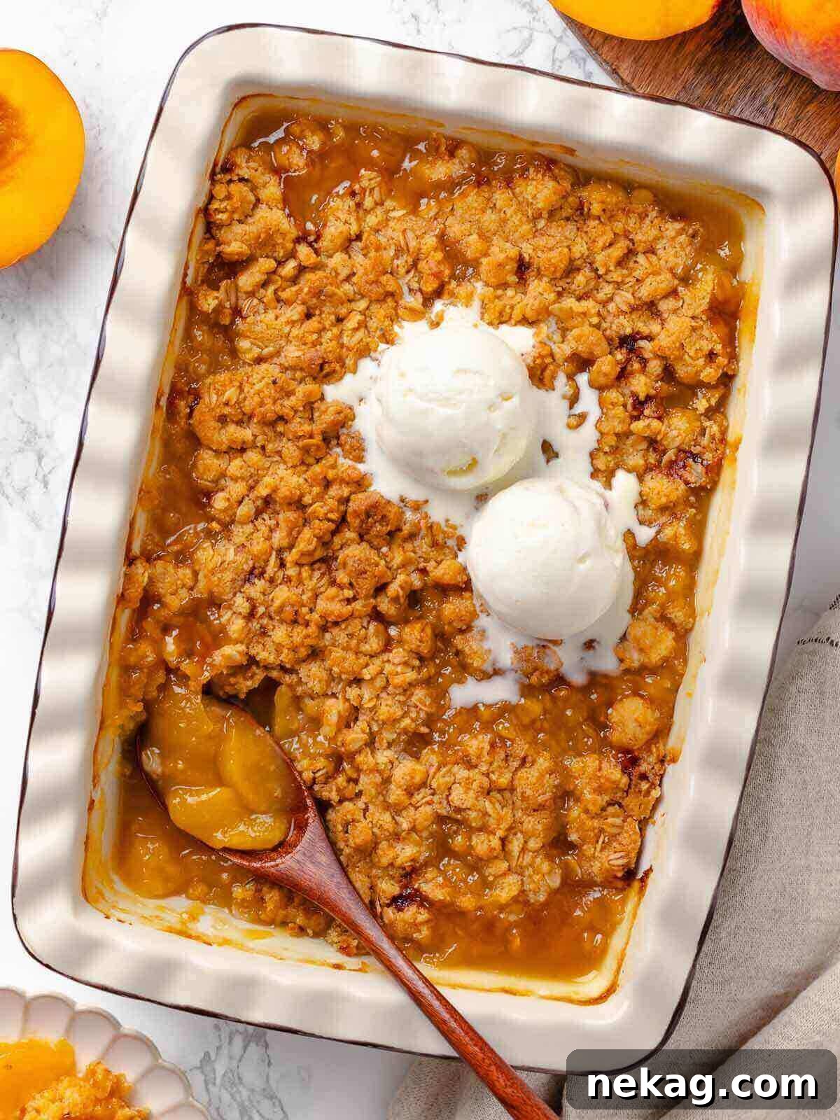Warm Buttery Peach Crisp 2 A baked peach crisp with melting vanilla ice cream on top, showcasing the perfect golden-brown crisp texture and juicy filling.