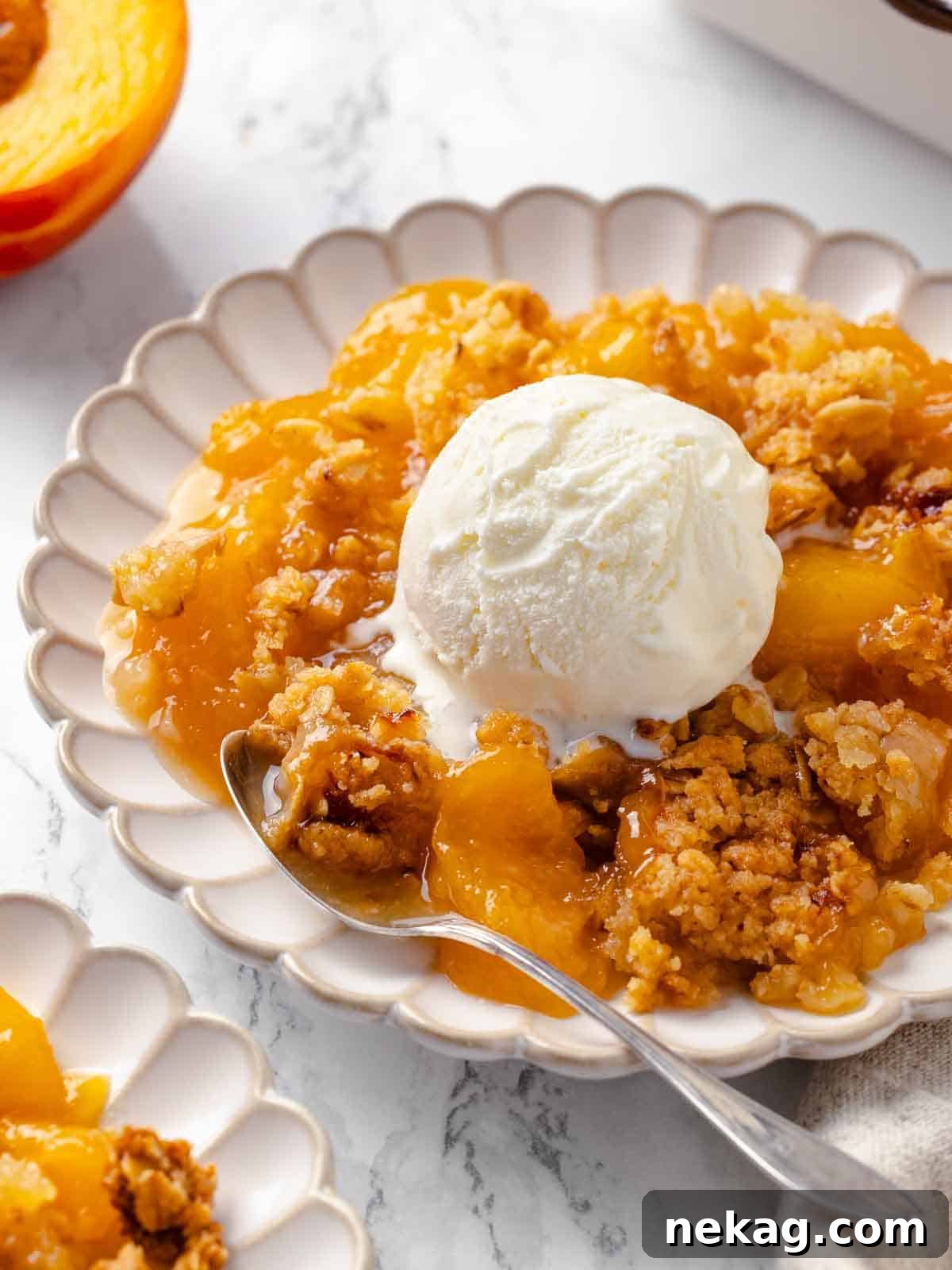 Warm Buttery Peach Crisp 13 A scoop of ice cream melting into a warm bowl of peach crisp, ready to be enjoyed.
