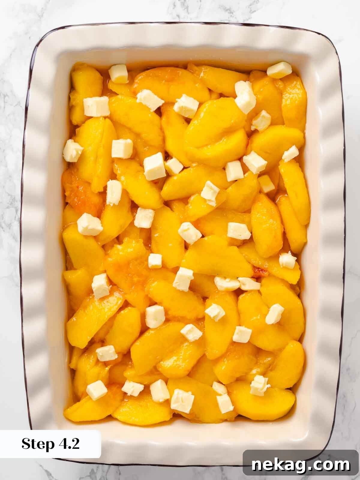 Warm Buttery Peach Crisp 10 Sliced peaches dotted with butter, ready to be topped with the streusel for peach crisp.