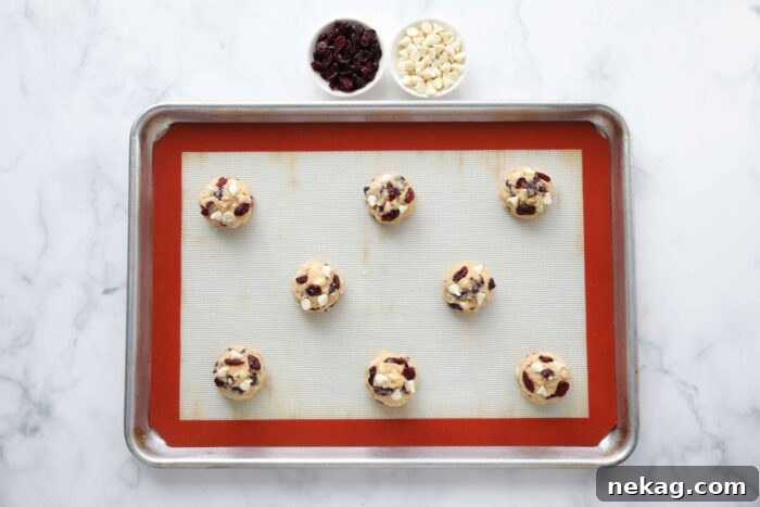 Cookie dough balls neatly arranged on a baking sheet, ready for the oven.