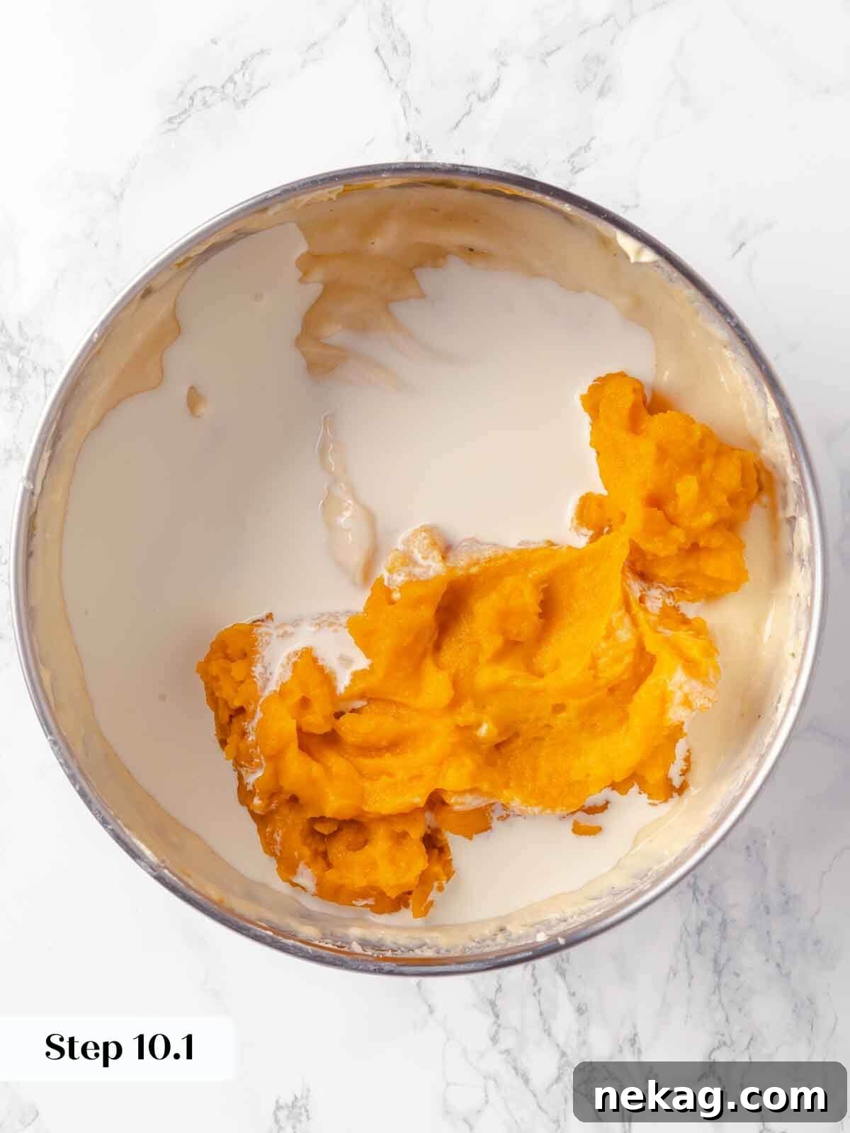 Velvet Pumpkin Bliss 14 Adding pumpkin puree to the cheesecake batter during preparation.
