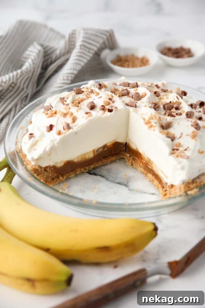 Effortless Banoffee Bliss 3 Slices removed from banoffee pie showing layers of graham cracker crust, dulce de leche caramel, bananas, whipped cream and toppings.