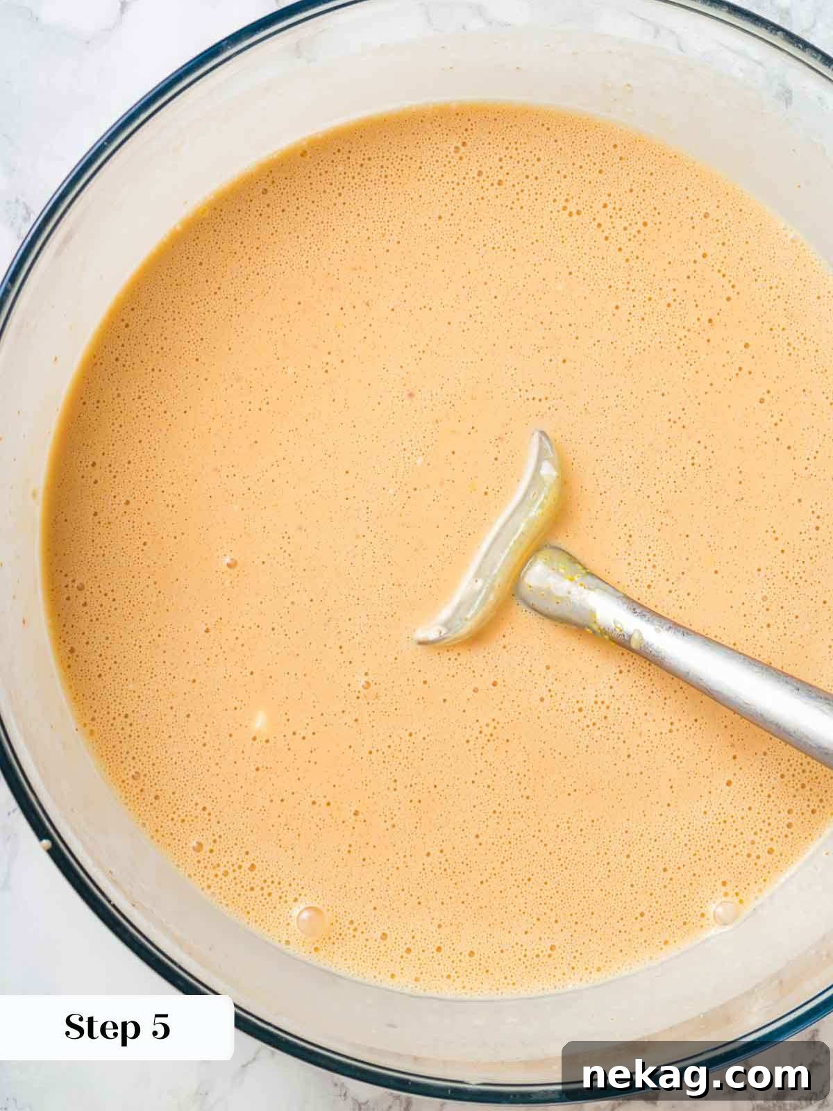 Fresh Peach Bliss 8 The finished peach ice cream base, a smooth, pale orange liquid in a large bowl, ready for chilling before churning.