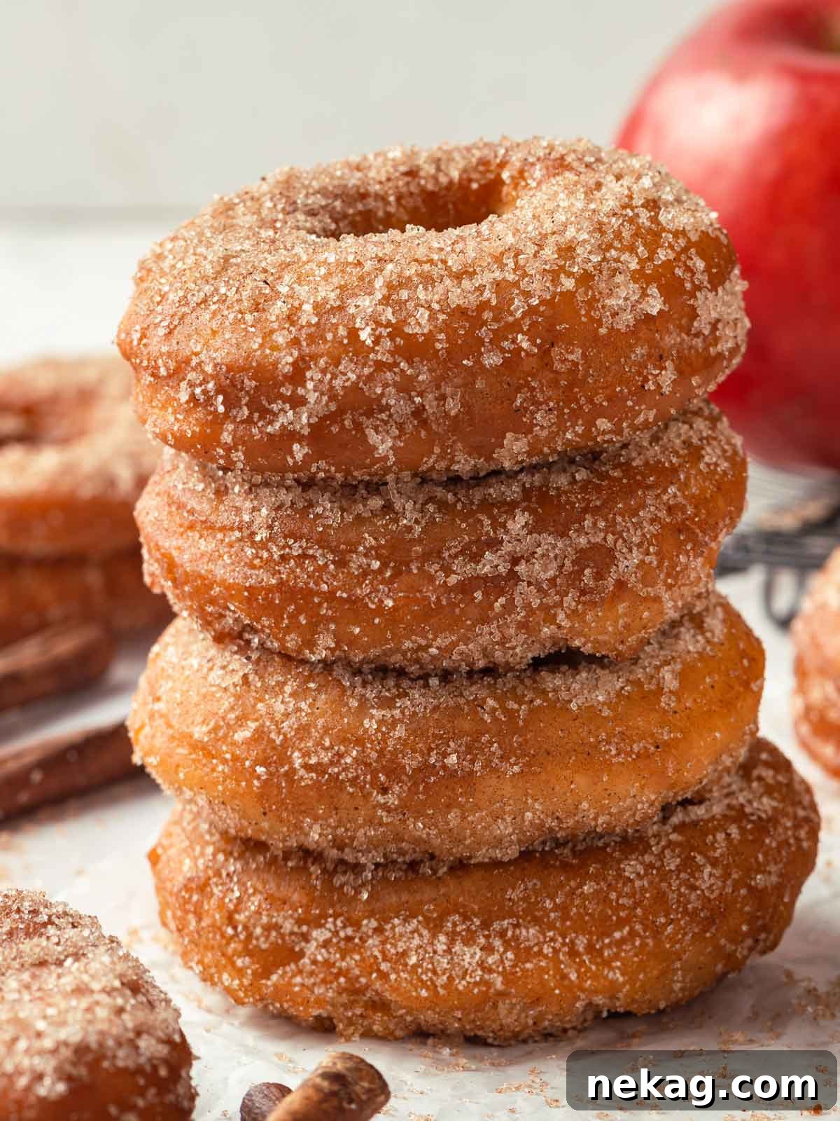 Harvest Apple Cider Donuts 3 Four apple cider donuts stacked on top of each other, capturing their fluffy, sugary appearance.