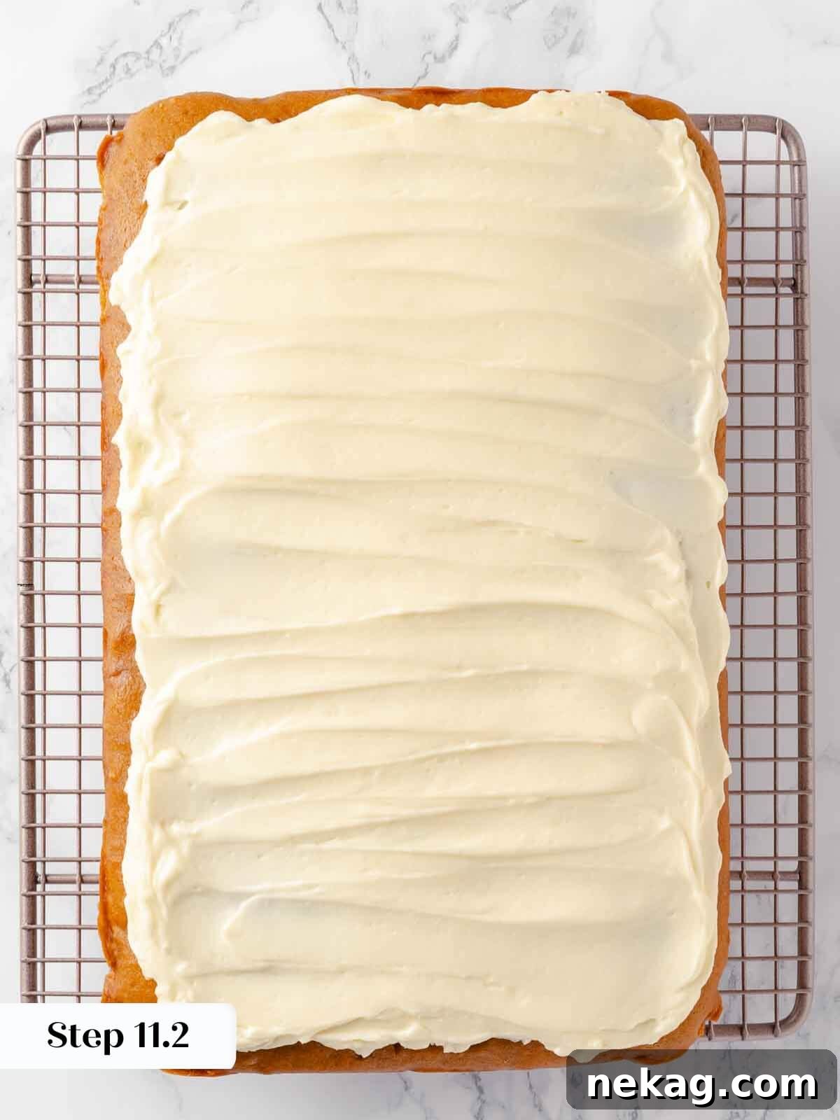 Autumn Spice Squares 16 Cream cheese frosting being spread smoothly and evenly over the baked pumpkin bars.