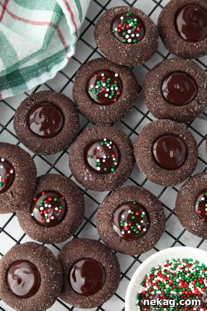 Mixture of chocolate thumbprint cookies on wire cooling rack. Some with sprinkles, some without.