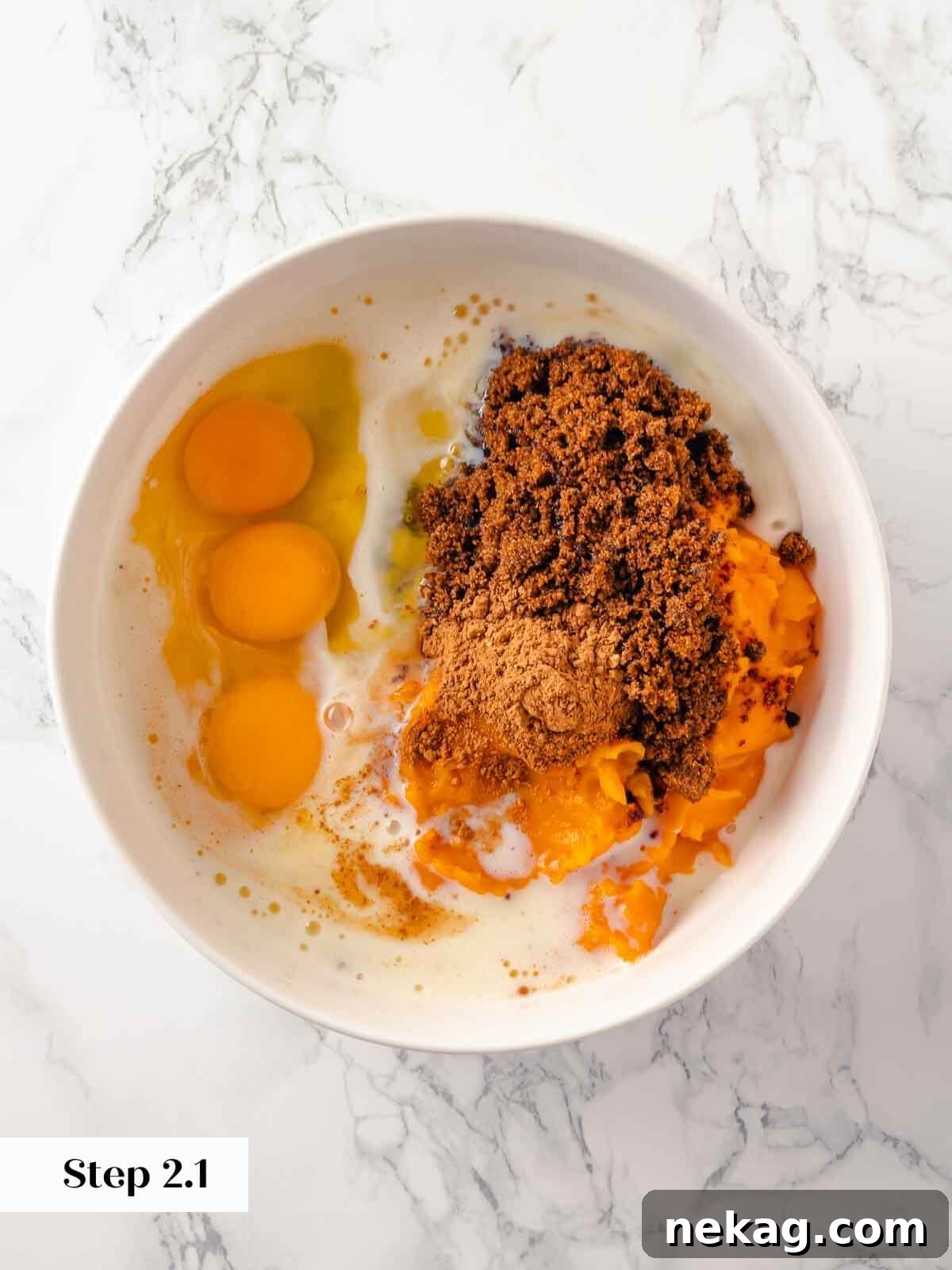 All the raw, essential ingredients for the pumpkin dump cake, including whole eggs, a can of pumpkin puree, and various spices, neatly arranged on a countertop before they are mixed together to form the base.