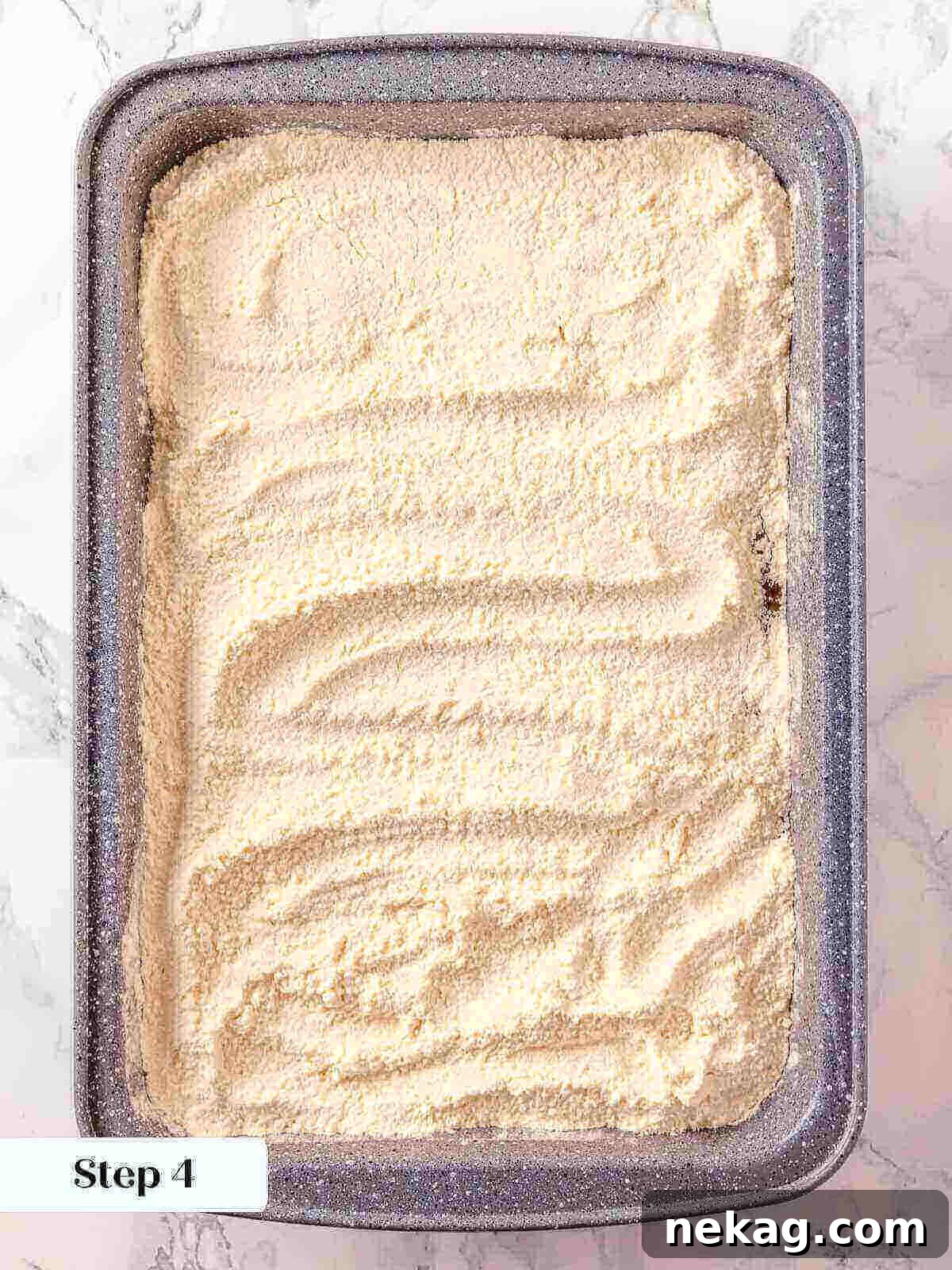 Dry yellow cake mix evenly sprinkled and spread over the top of the pumpkin dump cake ingredients in a baking dish, forming the second distinct layer.