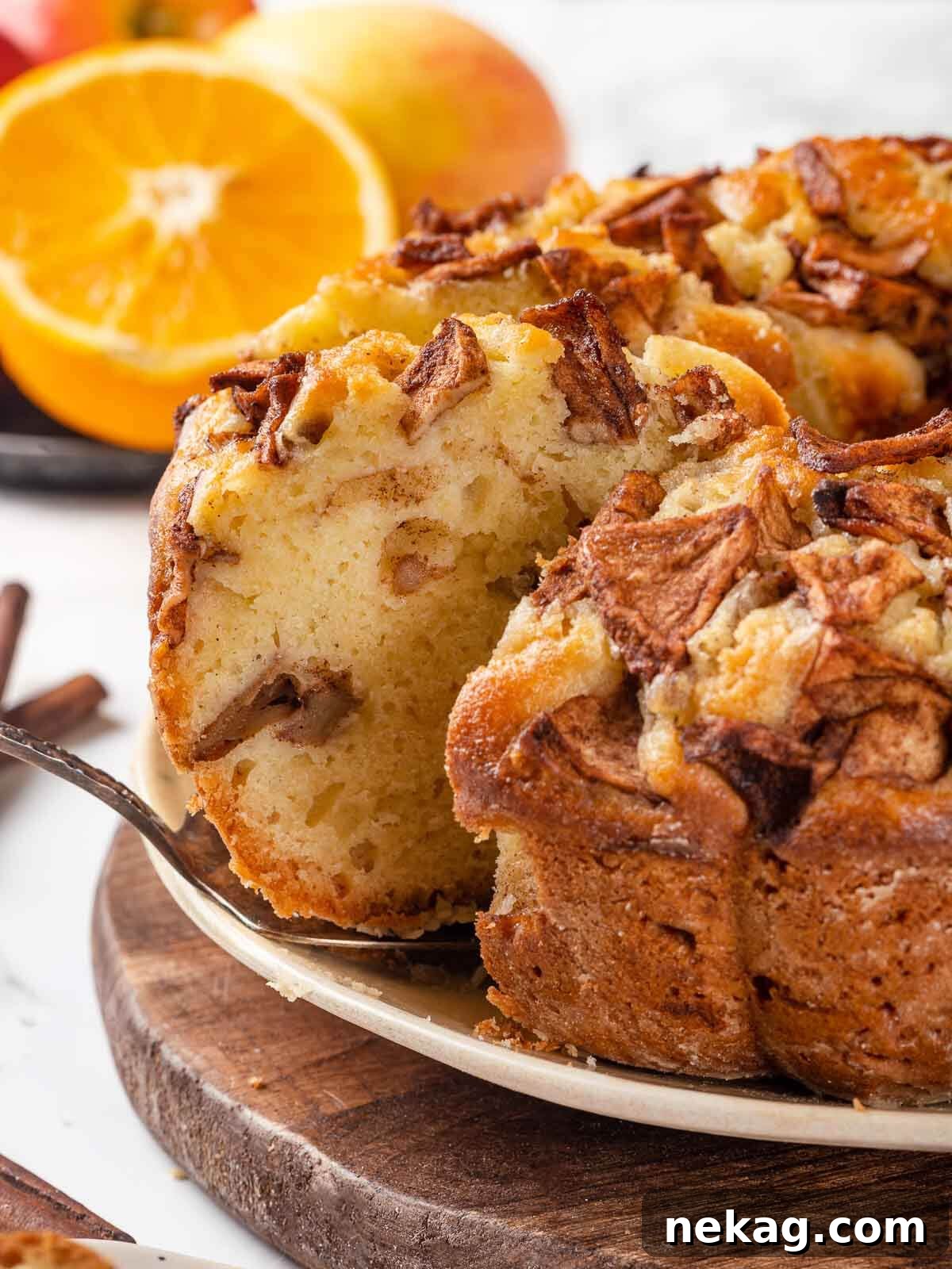 Spiced Apple Harvest Cake 2 A silver cake server next to a golden brown Jewish apple cake on a elegant serving plate, ready to be enjoyed.