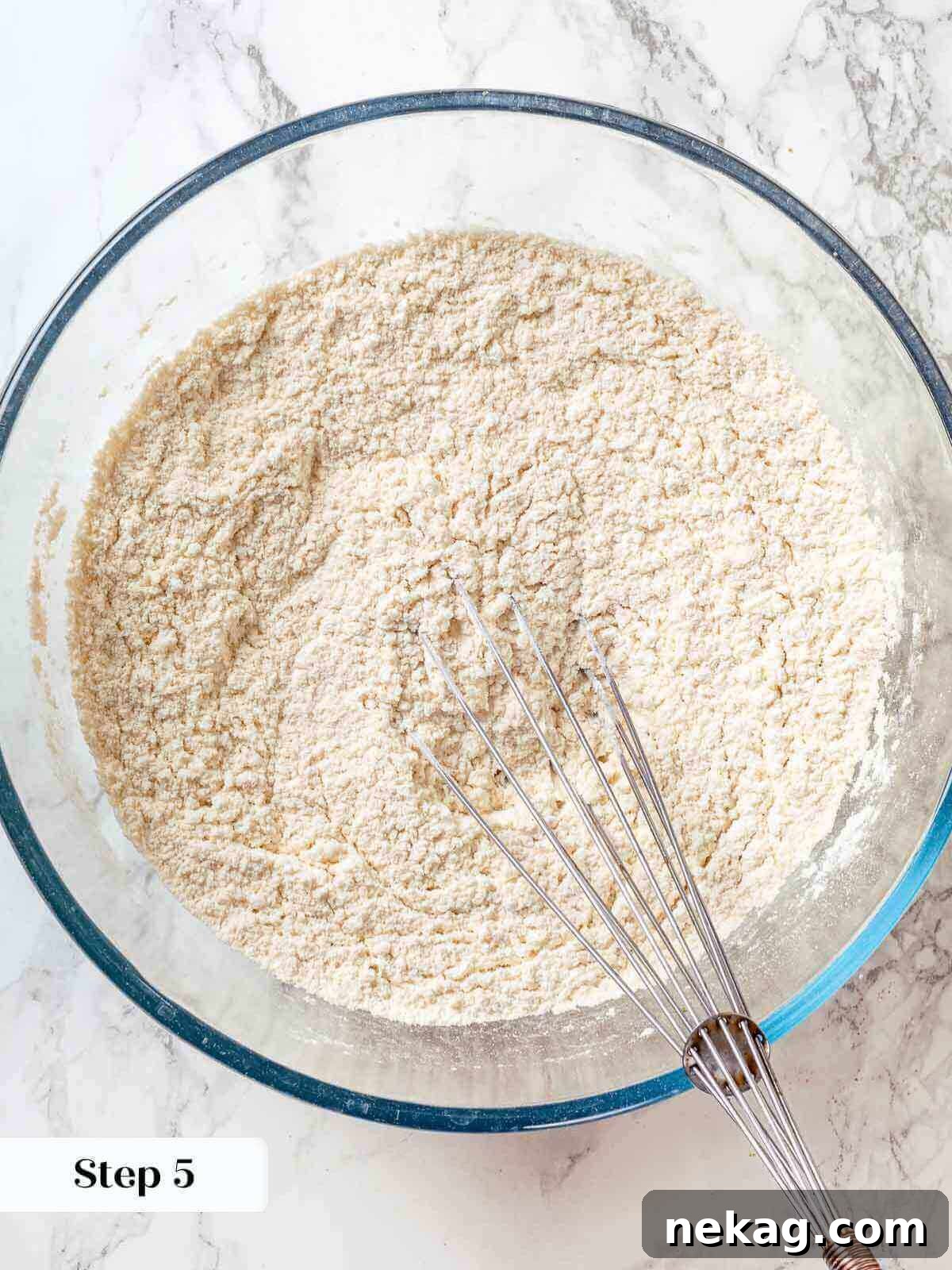 Spiced Apple Harvest Cake 6 Dry ingredients for a Jewish apple cake, including flour, baking powder, and salt, being whisked together in a clean bowl.