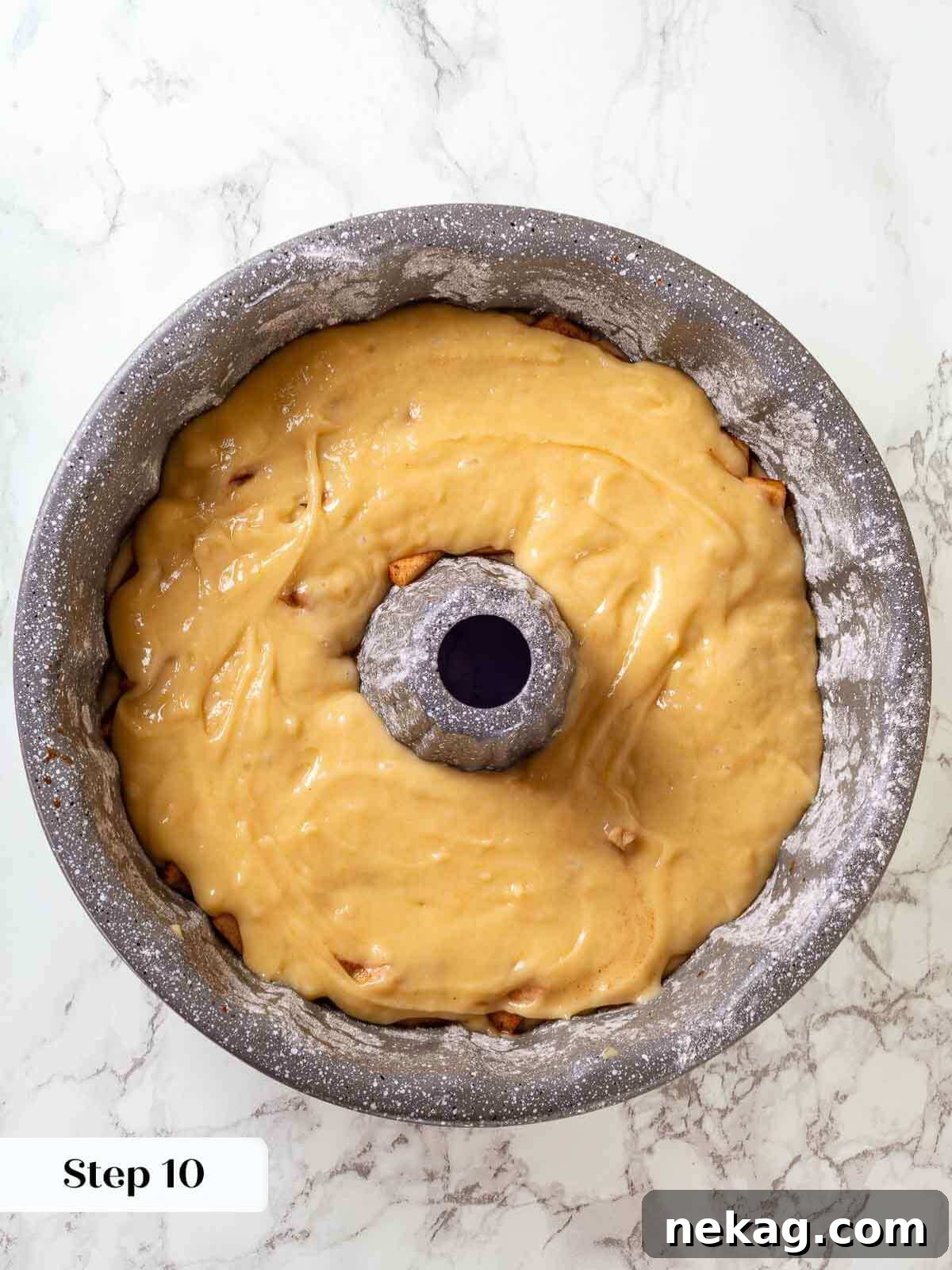 Spiced Apple Harvest Cake 9 The second layer of cake batter being poured and spread over the initial apple layer in the baking pan, creating distinct strata.