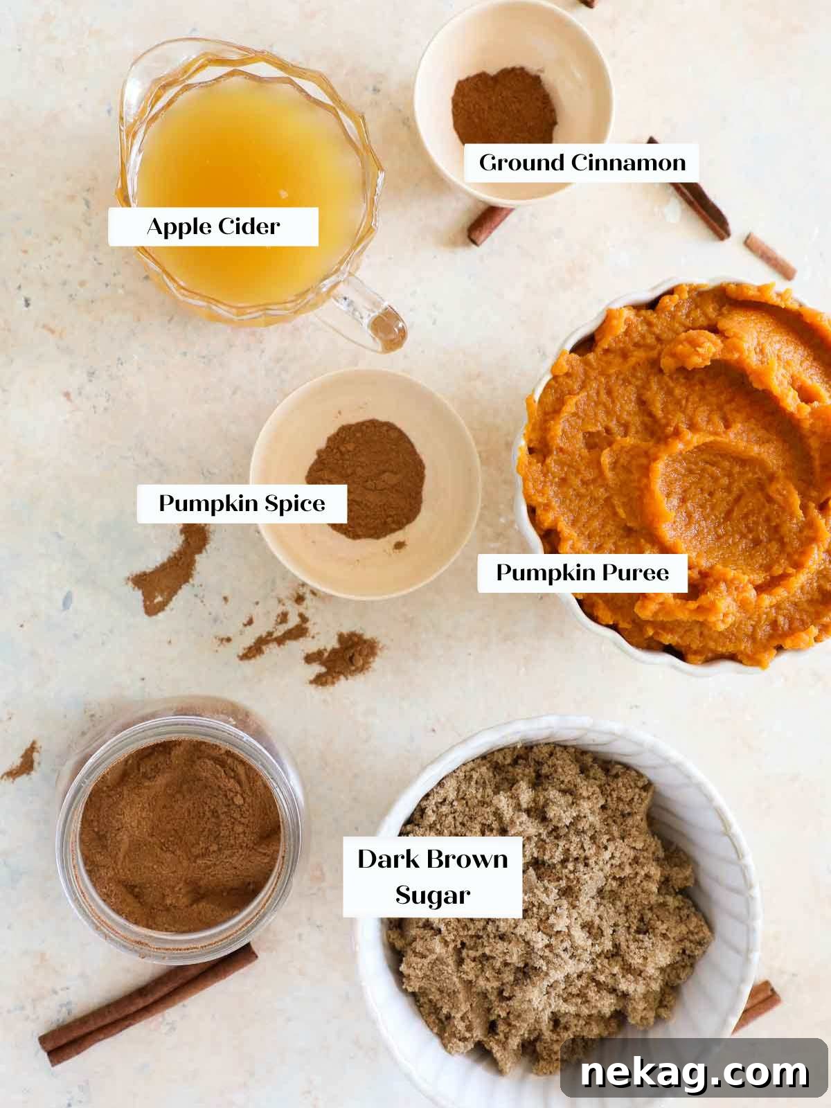 An organized flat lay of ingredients for pumpkin butter, including canned pumpkin puree, apple cider, brown sugar, cinnamon, and pumpkin pie spice.