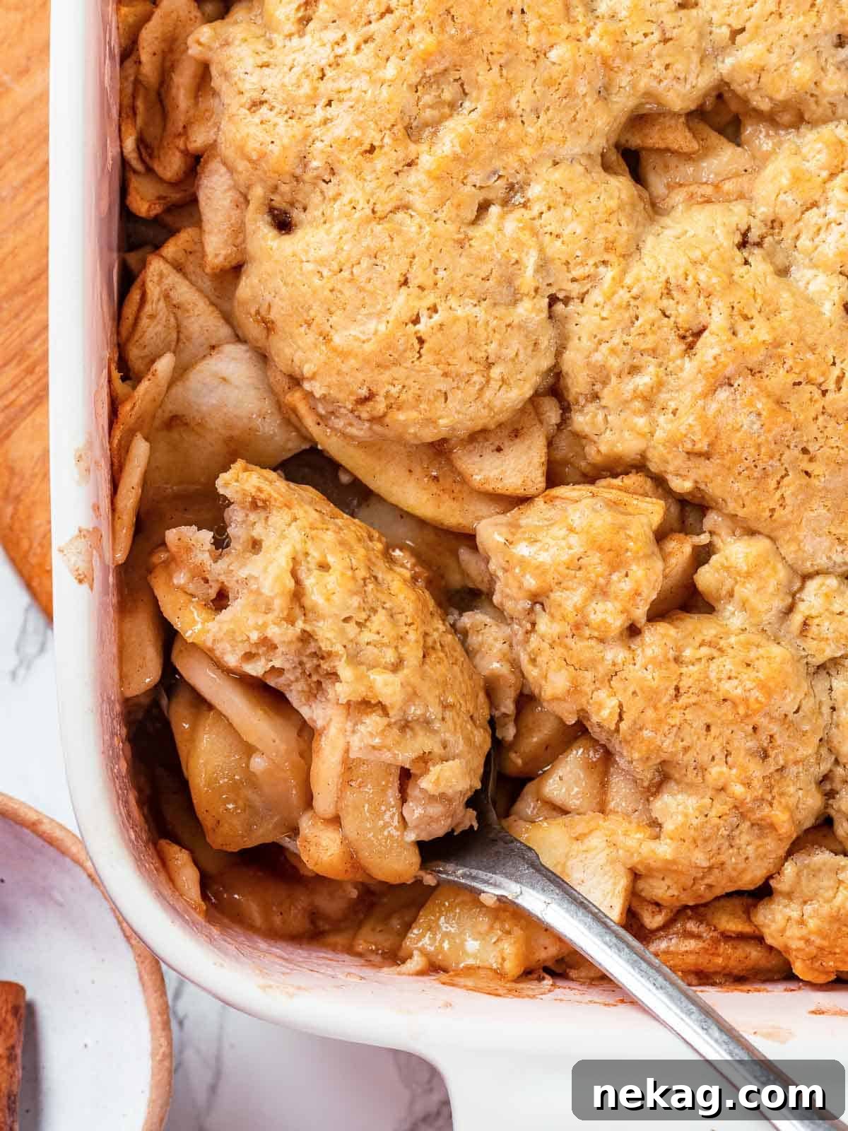 Baked apple cobbler with a golden brown biscuit topping.