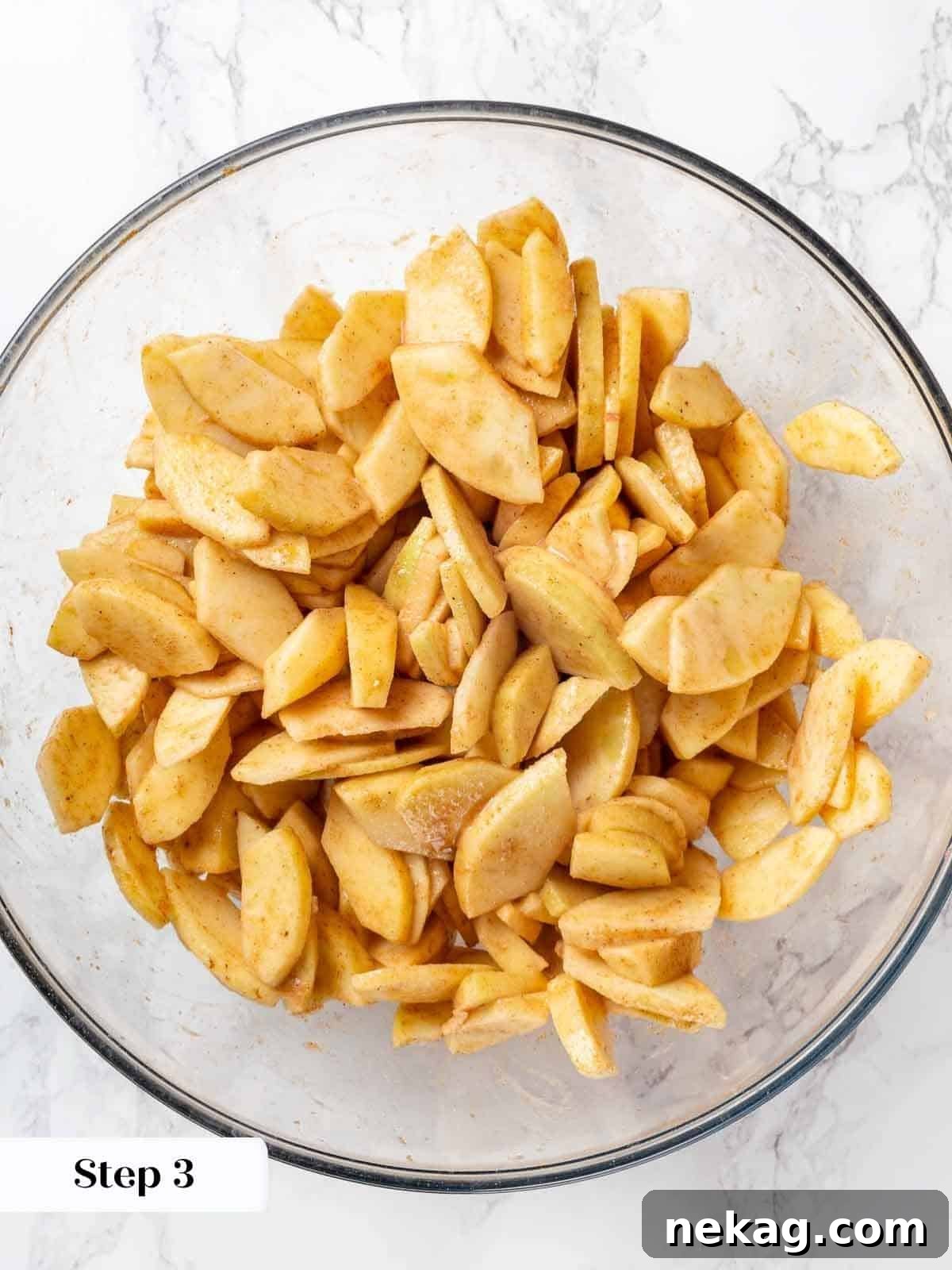 Apple slices mixed with spices and sugar for cobbler filling.