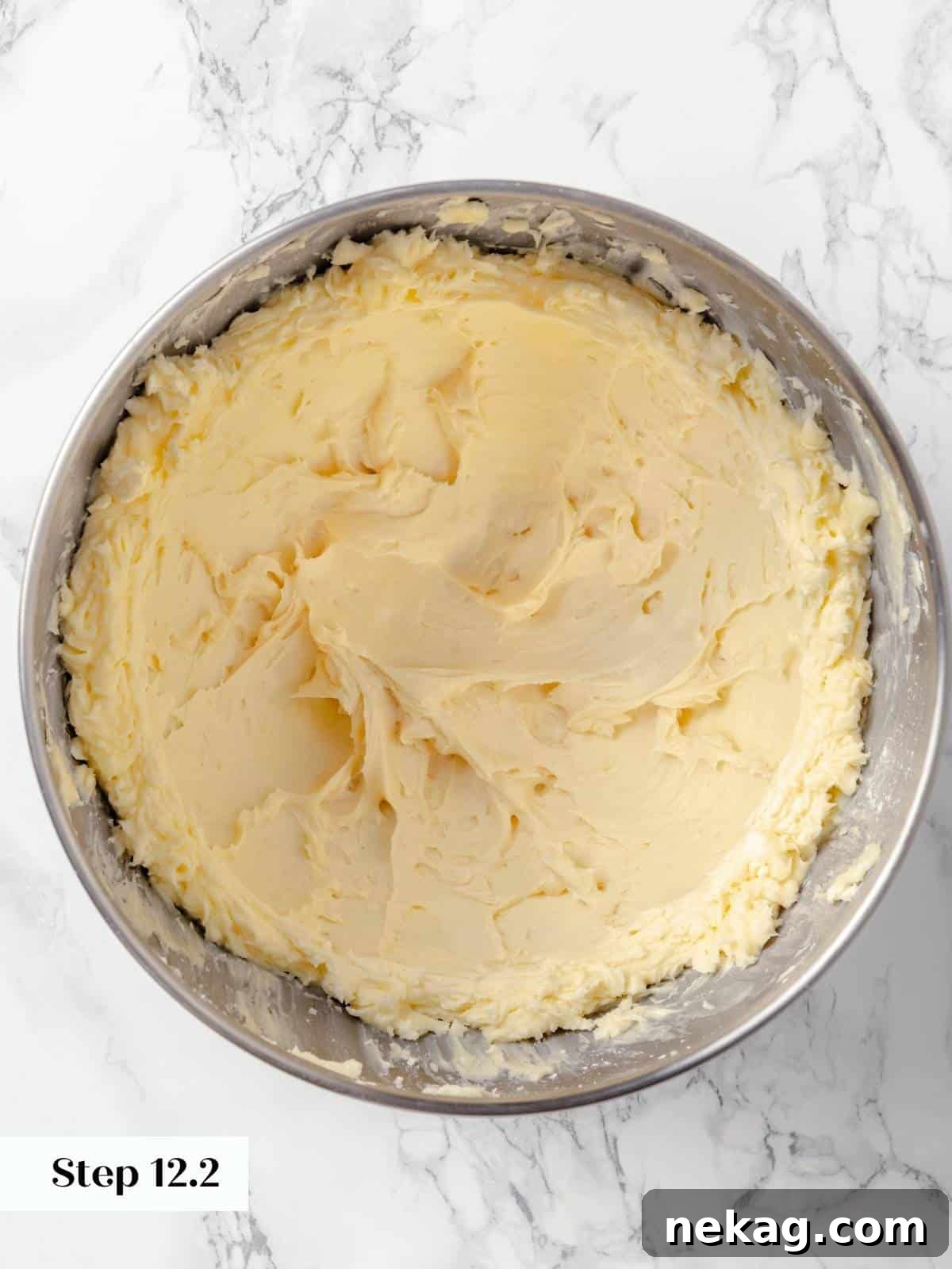 Spiced Applesauce Comfort Cake 18 The finished maple cream cheese frosting, smooth and creamy, in a metal mixing bowl.