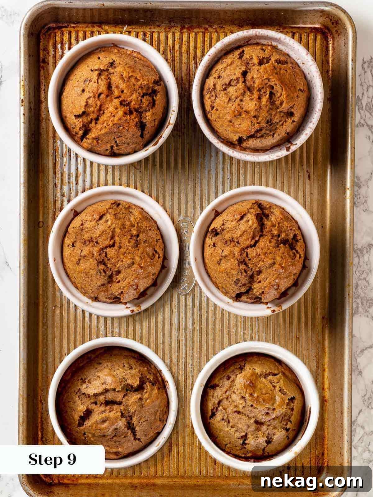 Freshly baked sticky toffee pudding in ramekins, with a golden-brown top, just out of the oven.