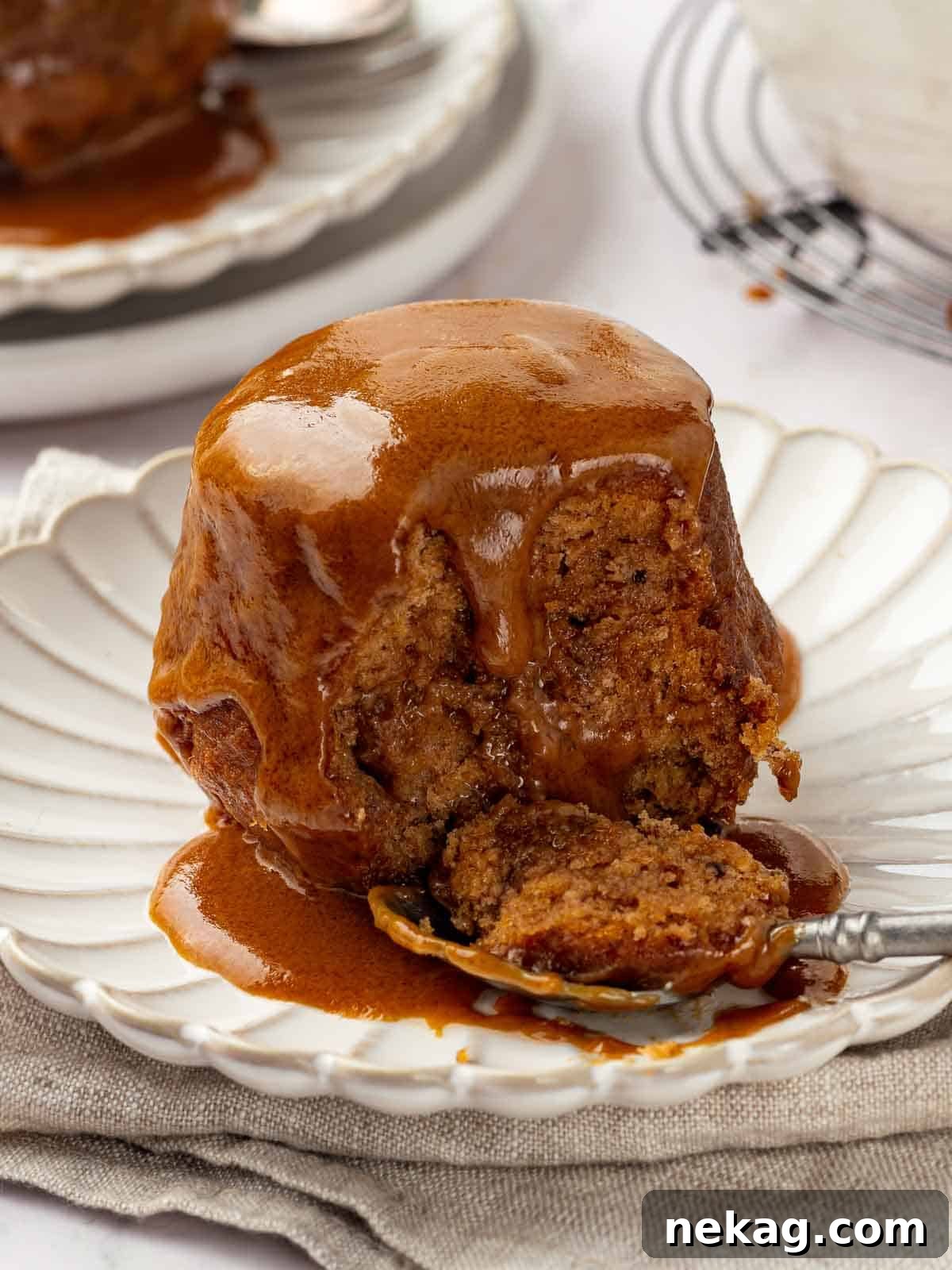 A single serving of sticky toffee pudding on a plate, elegantly drizzled with the homemade toffee sauce, ready to be enjoyed.