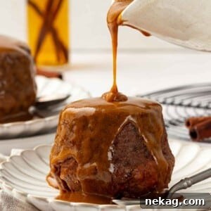 Sticky toffee pudding fully soaked in rich toffee sauce, showcasing its indulgent appearance.