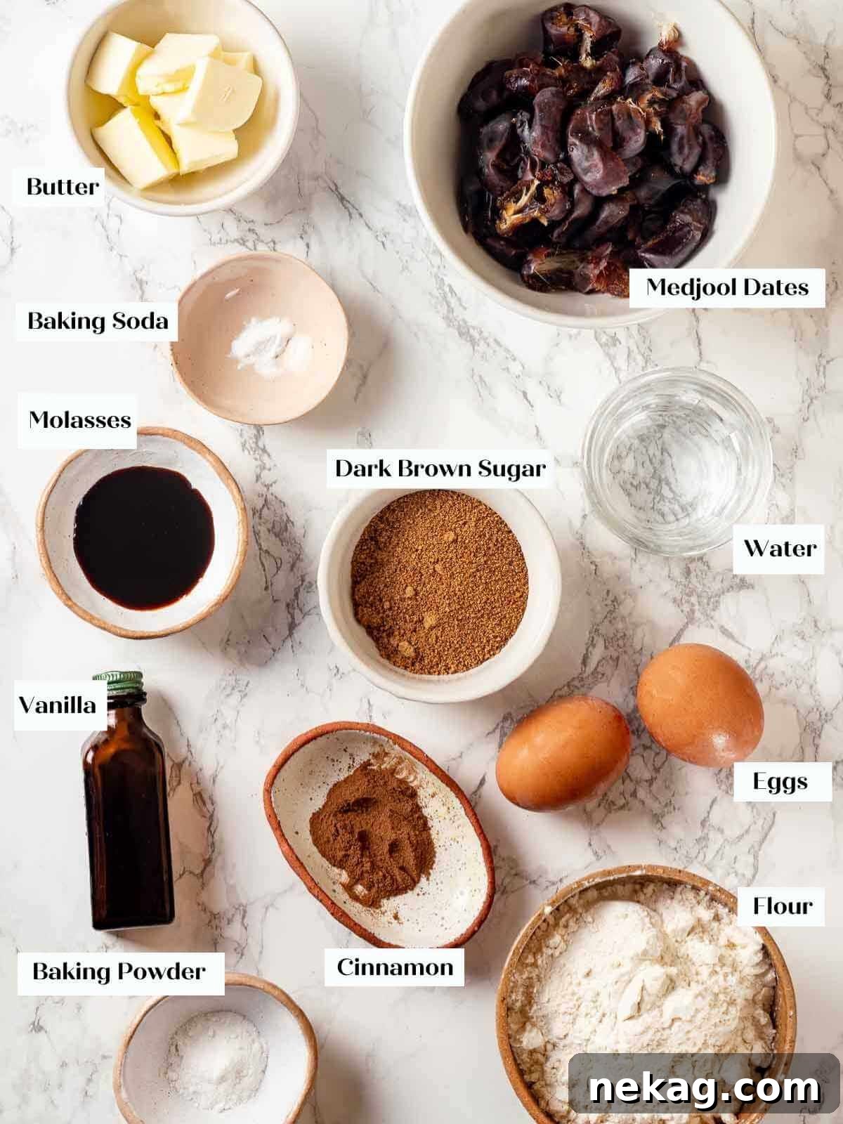 Ingredients for sticky toffee pudding arranged on a pristine white marble surface, ready for baking.