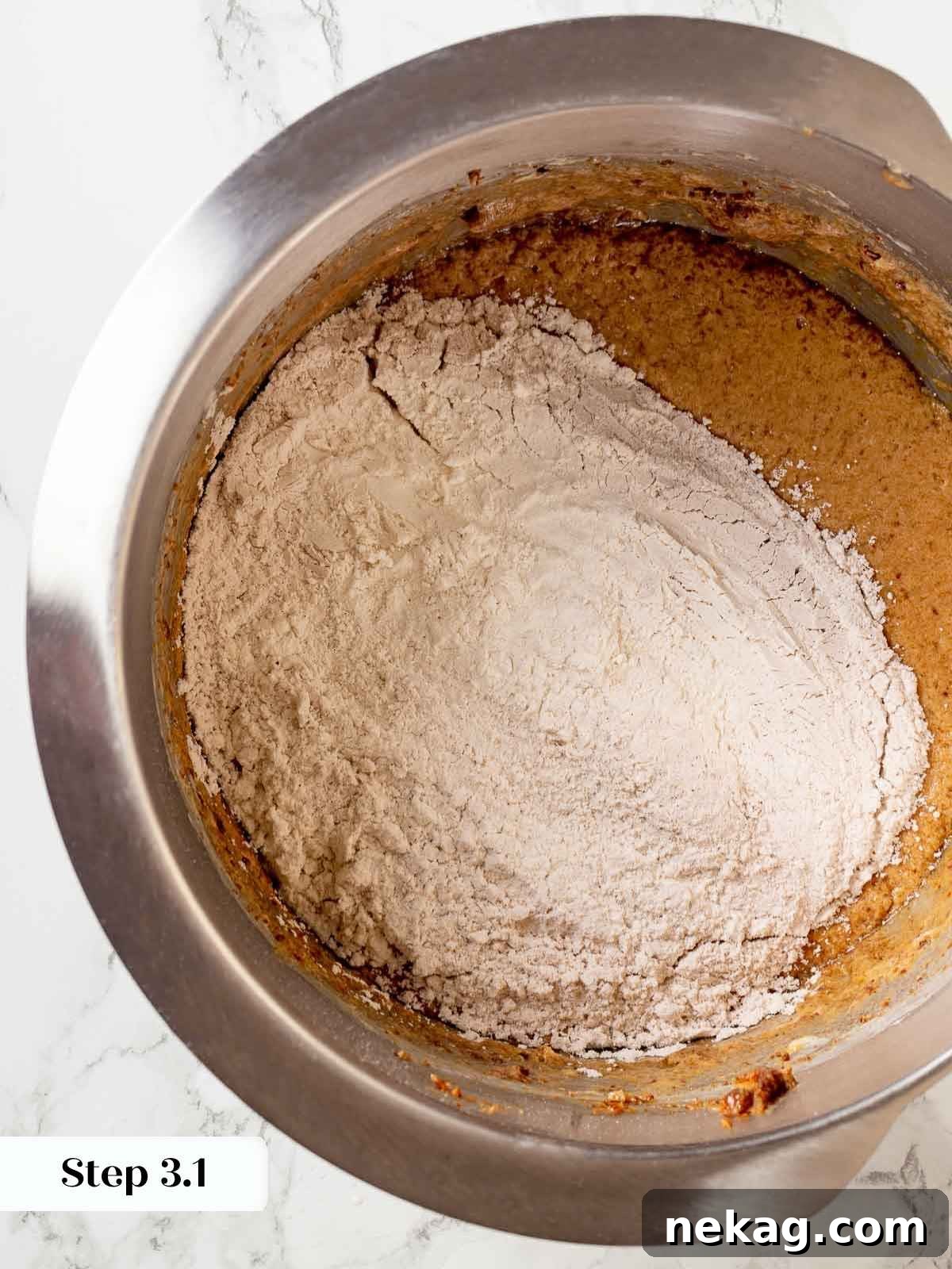 Flour and cinnamon being meticulously mixed into the sticky toffee pudding batter, ensuring even distribution of flavors.