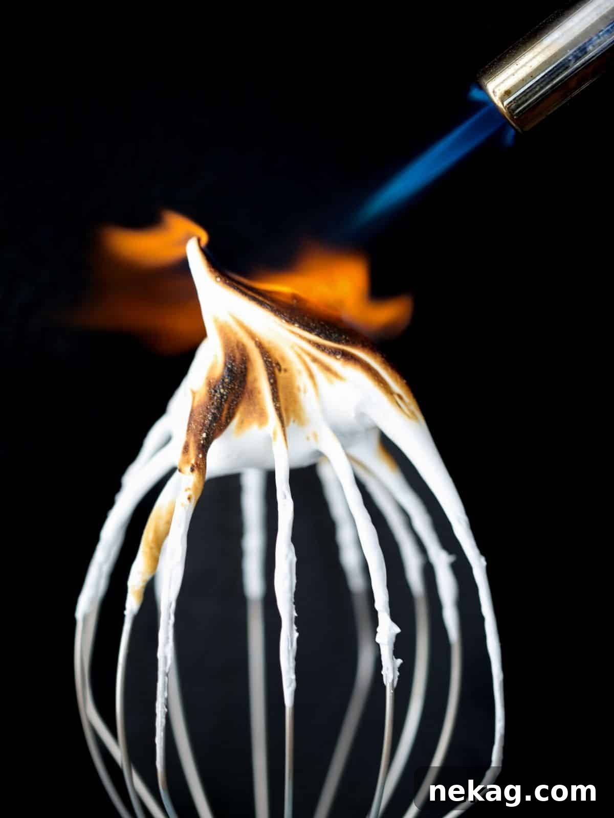 A butane torch expertly caramelizing the surface of frosting on a dessert, creating a perfectly golden finish.