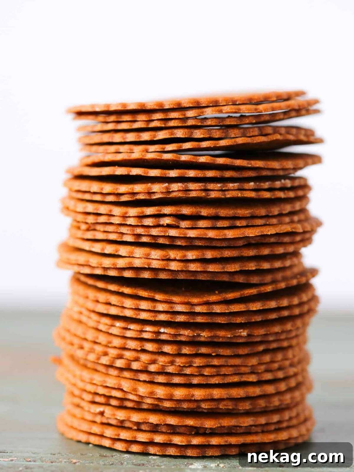A perfectly neat stack of thin, crispy Moravian cookies, meticulously arranged and ready for delightful holiday snacking.