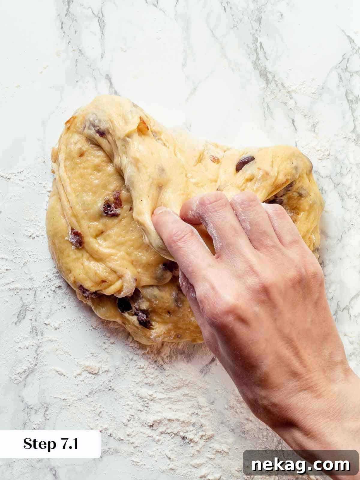 The four corners of panettone dough being folded inward on a work surface during pre-shaping.