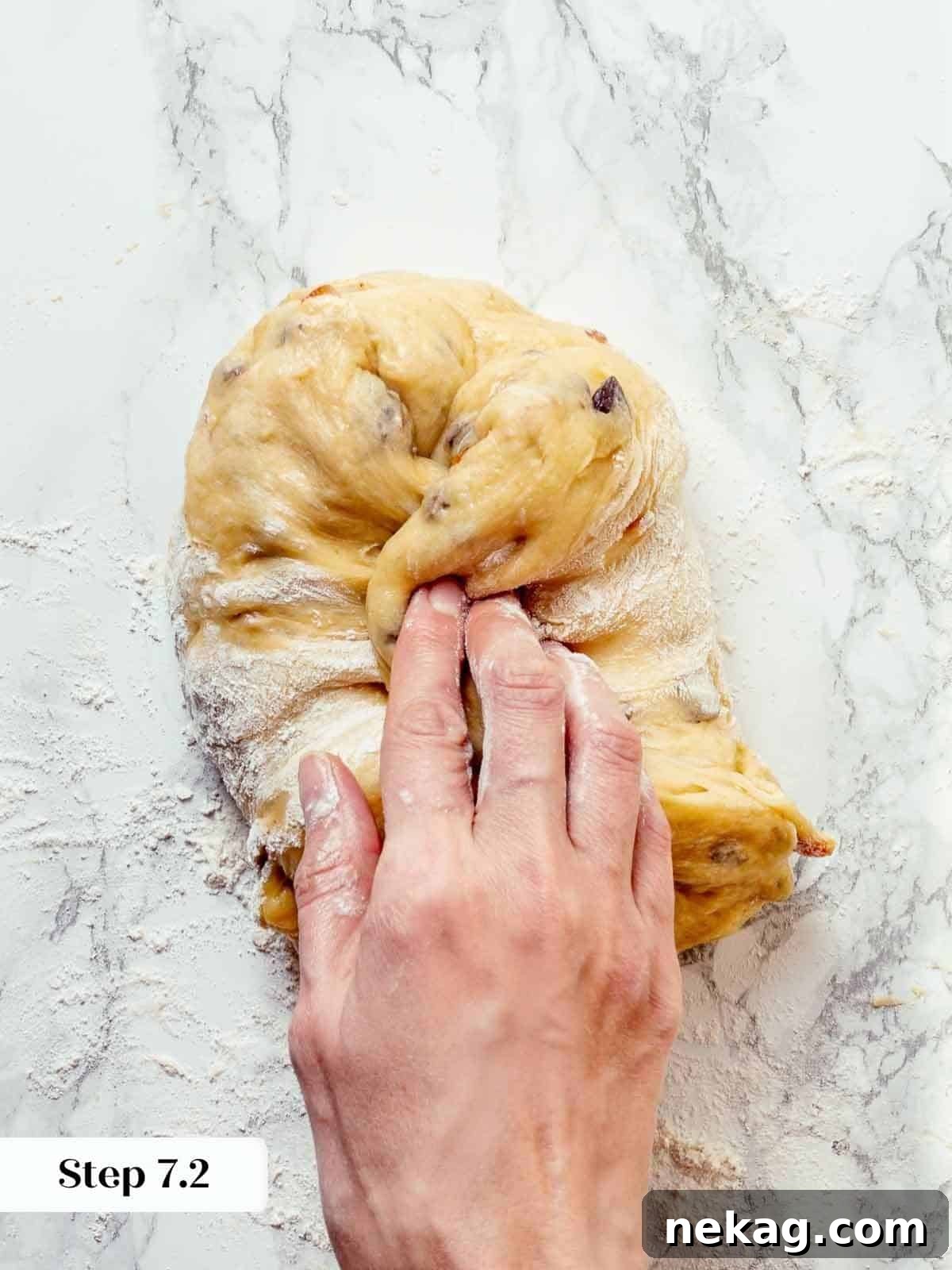 Panettone dough being gently folded and shaped during the pre-shaping process.
