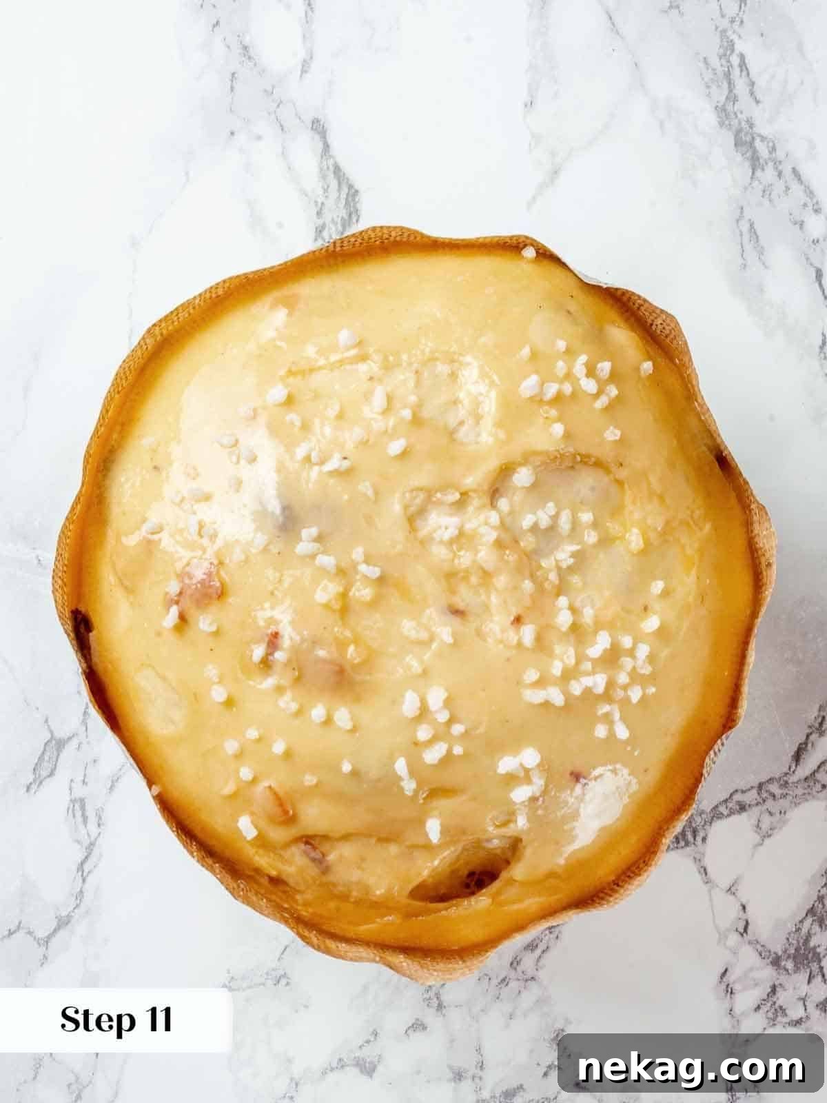 A close-up of sparkling pearl sugar topping, generously sprinkled on panettone dough before baking.