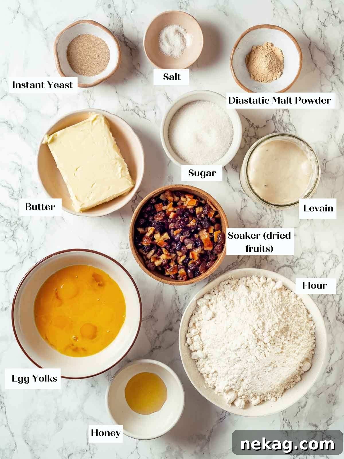 Ingredients for panettone neatly arranged on a white marble countertop.