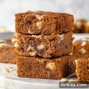 Festive Gingerbread Blondies 14 A beautifully arranged stack of three gingerbread blondies, showcasing their perfectly baked, chewy texture and inviting soft interior.