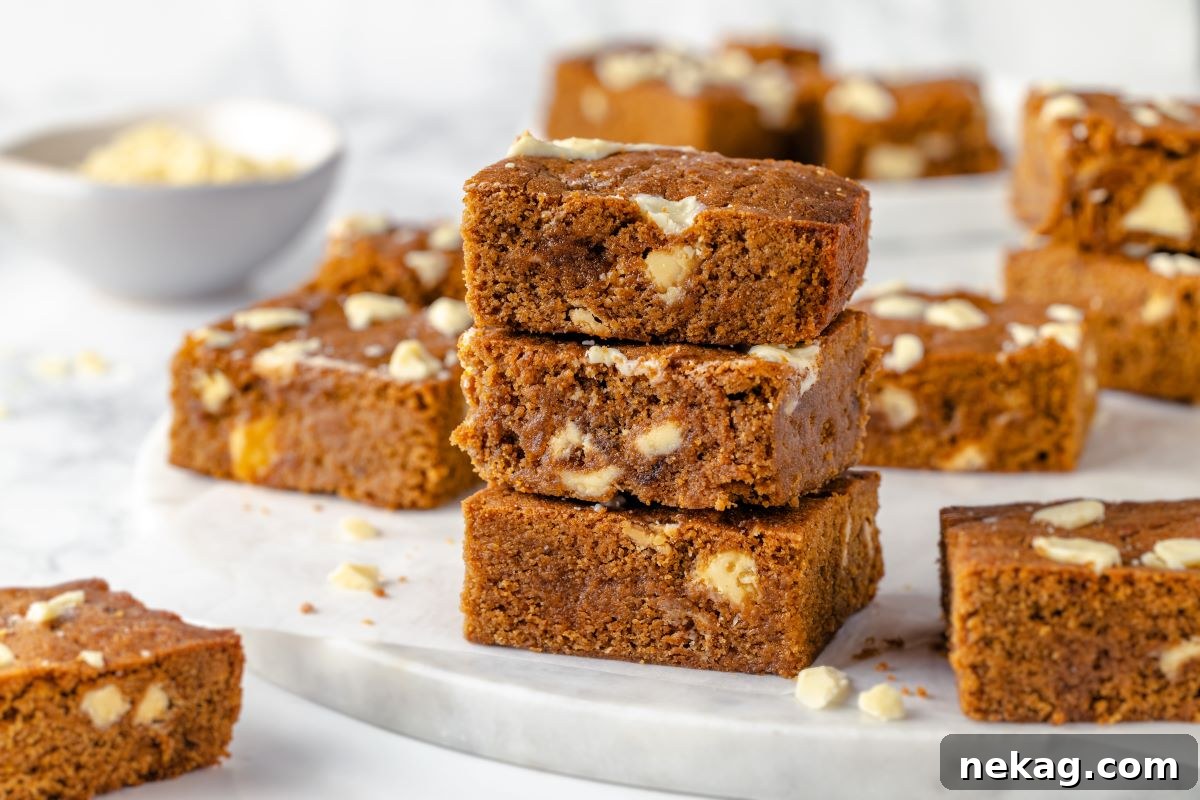 Festive Gingerbread Blondies 3 A fresh batch of golden-brown gingerbread blondies, perfectly baked and cooled, neatly cut into squares on a cooling rack.