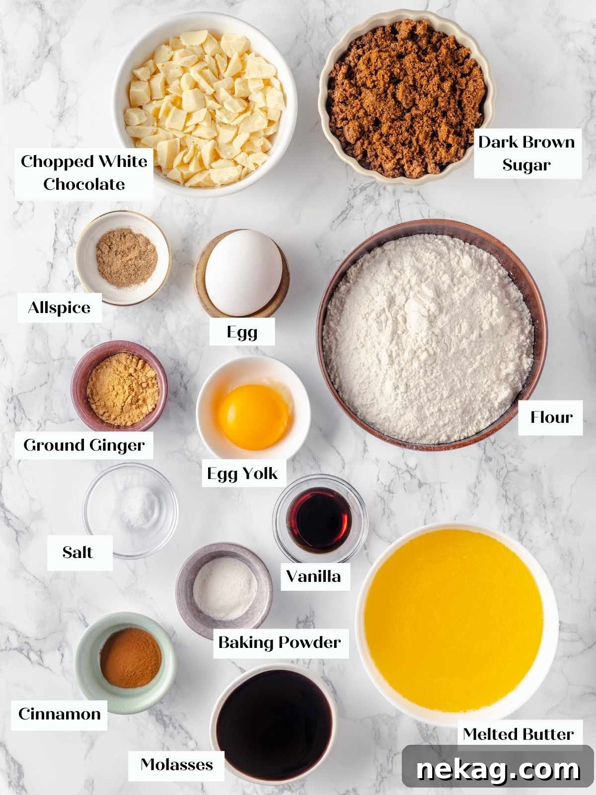 Festive Gingerbread Blondies 4 All the fresh ingredients for homemade gingerbread blondies neatly arranged on a white marble countertop, featuring a beautiful display of spices, flour, and softened butter.
