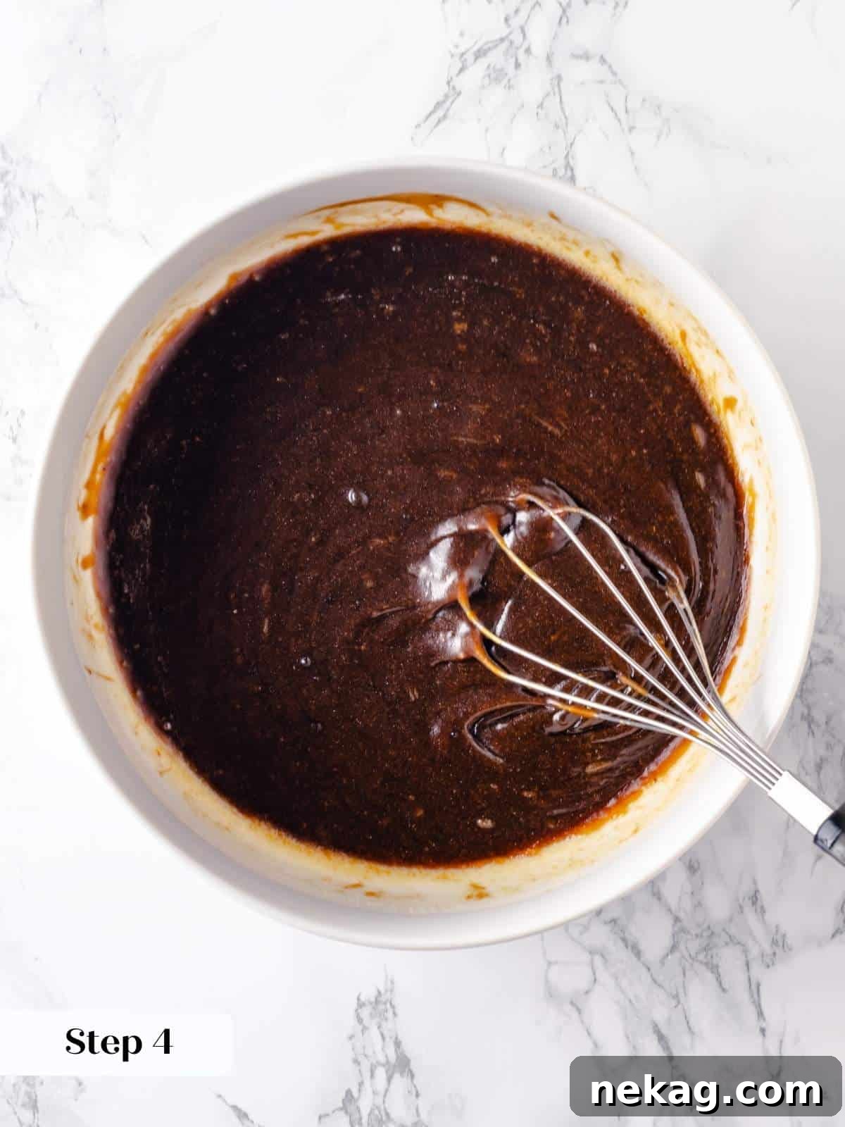 Festive Gingerbread Blondies 7 Wet ingredients for gingerbread blondies—eggs, melted butter, brown sugar, and molasses—being thoroughly whisked together in a bowl until smooth and evenly combined.