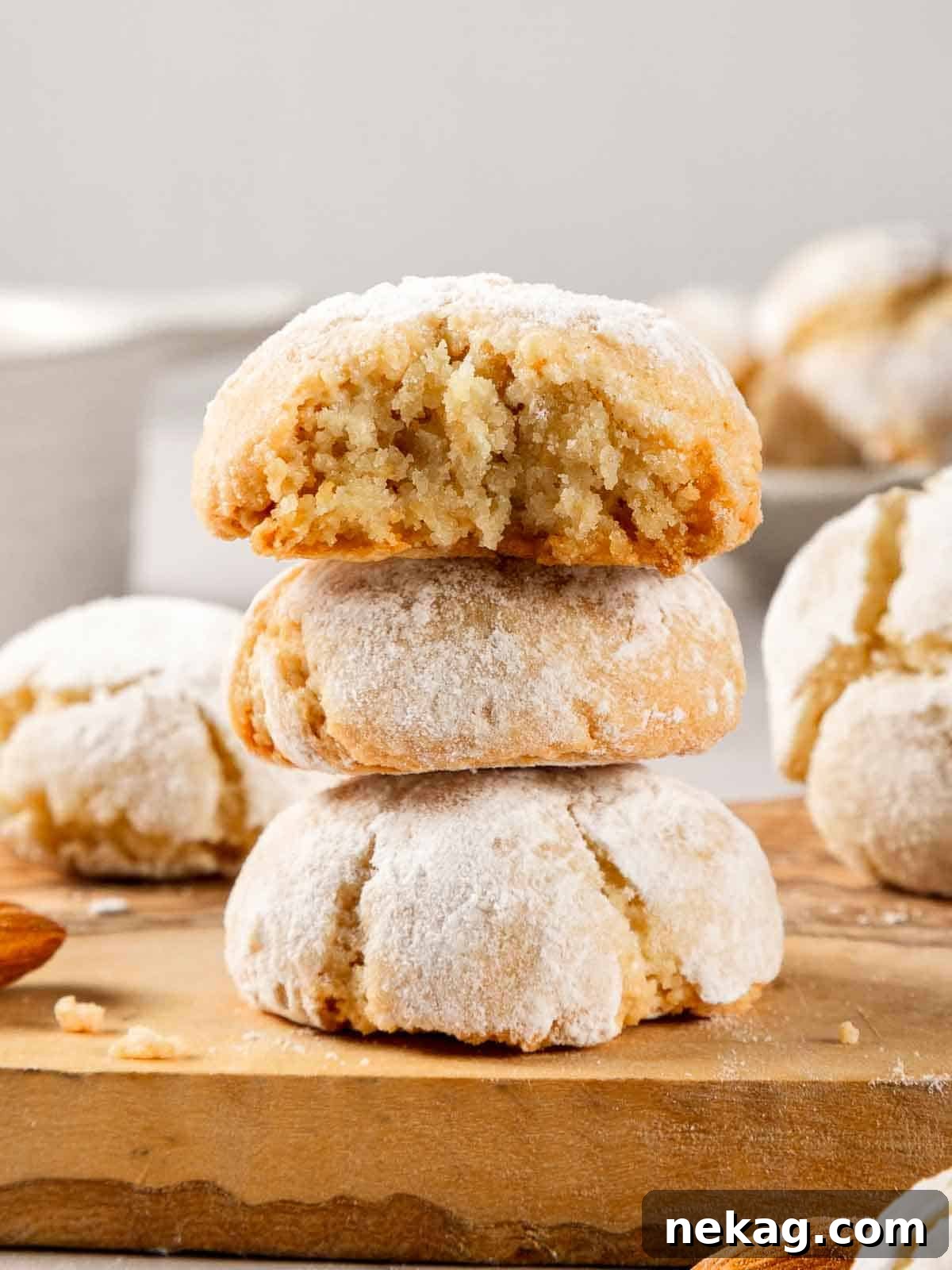 Delicate Amaretti Bites 13 A stack of soft amaretti cookies dusted with powdered sugar, ready to be served.