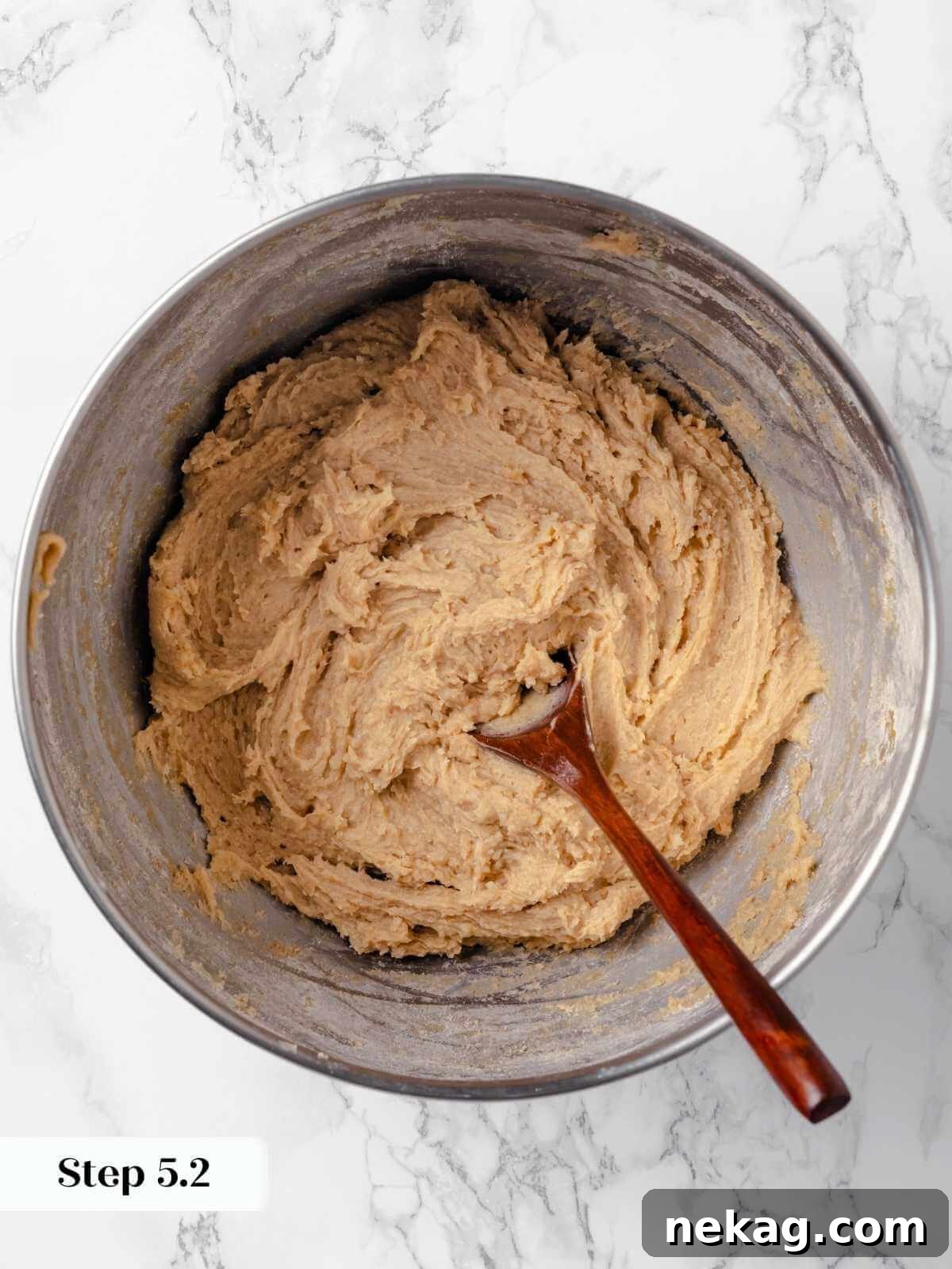 Hearty Cowboy Cookie Bake 12 The cookie dough in a mixing bowl after the dry ingredients have been mostly incorporated, showing a cohesive, slightly floury texture before the final mix-ins.